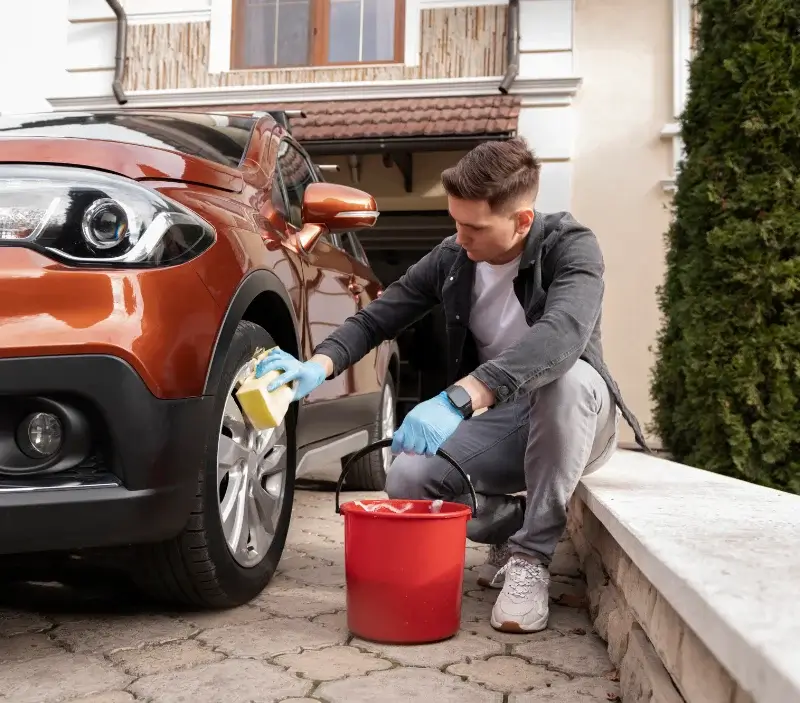 Lavage auto à domicile Villiers-le-Bâcle : professionnel intervenant sur un véhicule